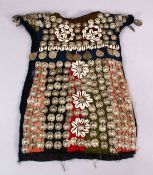 A 19TH CENTURY TURKISH SILVER ONLAID CHILDS DRESS, with silver roundel and shell applications.