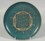 A CHINESE TURQUOISE GLAZED DISH, the centre with carved gilt Mongolian characters, the base with