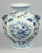 A CHINESE BLUE, WHITE AND RED PORCELAIN TWIN-HANDLED VASE with raised decoration depicting grapes