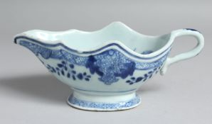 A CHINESE BLUE AND WHITE PORCELAIN SAUCE BOAT, the interior decorated with native flora. 21cm long
