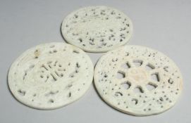 THREE CHINESE CARVED AND PIERCED HARDSTONE PLAQUES, 12cm diameter.