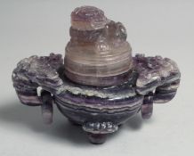 A CHINESE CARVED AMETHYST TRIPOD CENSER AND COVER, with twin drop ring handles, the cover carved