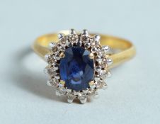 A GOOD 18CT GOLD SAPPHIRE AND DIAMOND CLUSTER RING.