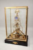 A GOOD BRASS AND ENAMEL MOON FACE SKELETON CLOCK surrounded by an eagle. 17ins high in a glass