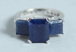 AN 18CT WHITE GOLD THREE STONE SAPPHIRE AND DIAMOND RING.