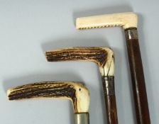 THREE VARIOUS WALKING STICKS with bone handles and silver band.