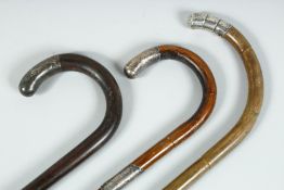 THREE VICTORIAN WALKING STICKS with silver tip handles.