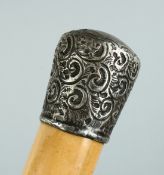 A VICTORIAN CANE with silver handle, repousse scroll decoration by W. Cornyns. 35ins.