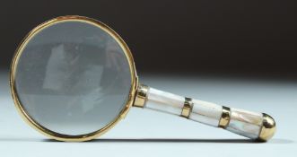 A SMALL MAGNIFYING GLASS with mother of pearl and gilt handle.
