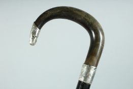 A VICTORIAN WALKING STICK with Rhino handle and engraved silver band and tip. Birmingham, 38ins