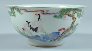 A CHINESE BOWL decorated with storks and flowers. 6ins diameter.