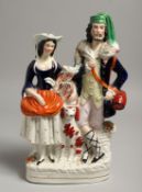 A STAFFORDSHIRE FLAT BACK GROUP, two figures, a goat and a dog. 12ins high.