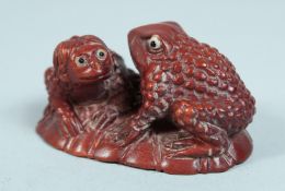 A JAPANESE WOODEN FROG NETSUKE.