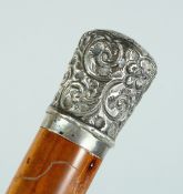 A VICTORIAN CANE with silver handle, repousse scroll decoration. London 1890. 35ins long.