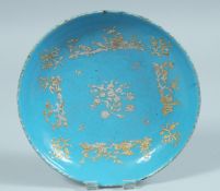 A 19TH CENTURY FRENCH ENAMEL CIRCULAR DISH with gilt decoration. 6.25ins diameter.