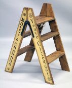 A PAIR OF CHAMPAGNE ADVERTISING FOLDING STEPS.