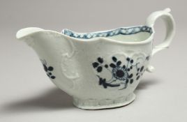 A JAMES PENNINGTON SMALL SAUCE BOAT moulded with panels painted in blue under glaze with flowers.