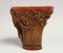 A GOOD CHINESE CARVED HORN LIBATION CUP carved with birds and lotus 5.5ins high.