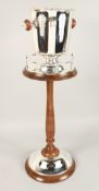 A TWO HANDLED ICE BUCKET on a wooden and plated stand.