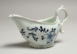 A JAMES PENNINGTON SAUCE BOAT with moulded borders painted in blue under glaze with flowers,