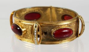 A VICTORIAN GOLD PLATED FLEXIBLE BRACELET set with red stones.