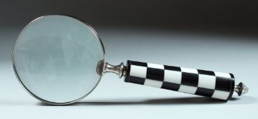A MAGNIFYING GLASS with checkered handle.