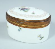 A 19TH CENTURY FRENCH OVAL BOX AND COVER with gilt mounts and painted with flowers. 3ins long.
