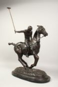 A LARGE BRONZE POLO PLAYER ON HORSEBACK on an oval marble base. 22ins long.