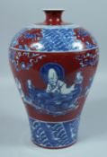 A CHINESE RED GROUND BLUE AND WHITE MEIPING VASE with figures. 12ins high.