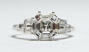 AN 18CT WHITE GOLD DIAMOND SET RING. The central diamond cluster of 1.17cts, the baguette diamonds