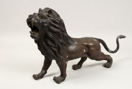 A BRONZE GROWLING LION. 22ins long