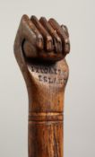 A PITCAIRN ISLAND WALKING CANE the handle as a fist. 36ins long.