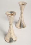 A PAIR OF.800 SILVER HAMMERED CANDLESTICKS. 6ins high.