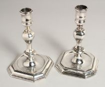 A MATCHED PAIR OF GEORGE I SILVER AND GEORGE II SILVER CAST CANDLESTICKS. London 1725 & 1735.