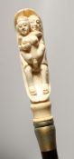 A BONE HANDLED WALKING STICK CARVE AS AN EROTIC SCENE. 35ins long
