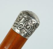 A VICTORIAN CANE with silver handle, repousse scroll decoration Birmingham, 1890, maker W & L. 36ins