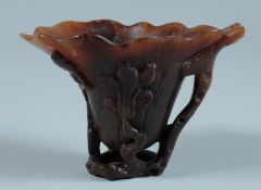 AN 18TH - 19TH CENTURY RHINO LIBATION CUP as a lotus flower with leaves. 3.25ins high x 4.5ins