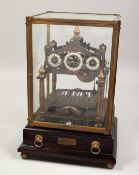 A CONGREAVE BRASS ROLLING BALL CLOCK in a glass case. 11ins high.