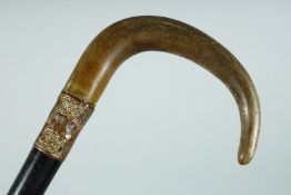 A VICTORIAN WALKING STICK with Rhino handle and gilt band., 35ins long.