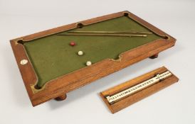 A RARE NUKU MINIATURE BILLIARD TABLE with slate base and green baize, in a fitted wooden case. 20ins