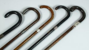 FIVE VICTORIAN WALKING STICKS with silver bands.