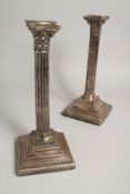 A PAIR OF CORINTHIAN COLUMN CANDLESTICKS on loaded square bases. 12ins high Sheffield 1919. Maker W.