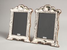 A PAIR OF SILVER SCROLLING PHOTOGRAPH FRAMES. 8ins x 6ins.