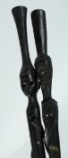 TWO HARDWOOD STICKS carved with bone handle carved with figures and snakes. 34ins long.