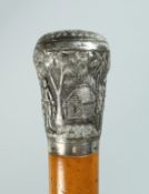 AN INDIAN CANE with silver handle decorated with figures, trees and buildings. 35ins long.