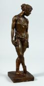 AFTER DEGAS A BRONZE STANDING FEMALE FIGURE on a square base. 13ins high.