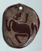 A NATIVE CARVED NUT PENDANT. 2.5ins x 2ins.