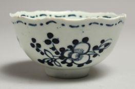 A JAMES PENNINGTON LIVERPOOL SERRATED RIM TEA BOWL painted with flowers in blue underglaze.