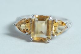 A SILVER AND CITRINE THREE STONE RING.
