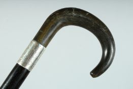 A VICTORIAN WALKING STICK with Rhino handle and engraved silver band. 34ins long.